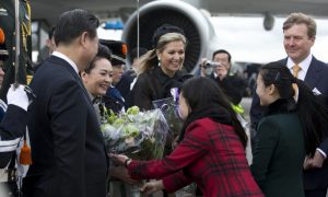 Chinese President Xi Jinping (L) and his wife Peng Liyuan (2nd-L) receive flowers as they are greeted by Dutch King Willem Alexander (R) and his wife Queen Maxima (C) upon arrival at Schiphol airport in Amsterdam on March 22, 2014 ahead of the March 24-25 Nuclear Security Summit (NSS) in The Hague. AFP PHOTO/POOL/PETER DEJONG
