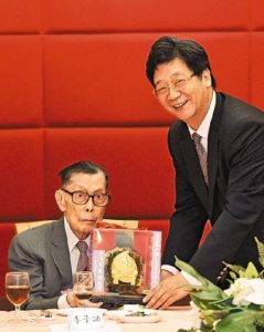 香港文汇报社董事长、社长王树成向老社长李子诵致送贺寿金桃，祝福李老健康幸福。